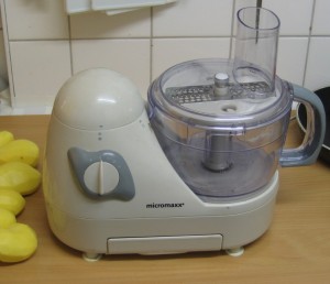 Elektrische Küchenmaschine zum Kartoffeln reiben, mit feiner Reibescheibe bestückt