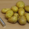 Kartoffeln vor dem Schaelen, mit Kartoffelschäler Kartoffeln vor dem Schaelen, mit Kartoffelschäler