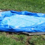 Den Pool mit einer dichten Plastikfolie unterlegen und auf der Fläche ausbreiten