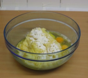 Geriebene Kartoffeln in der Schüssel mit Mehl, Eiern und Salz